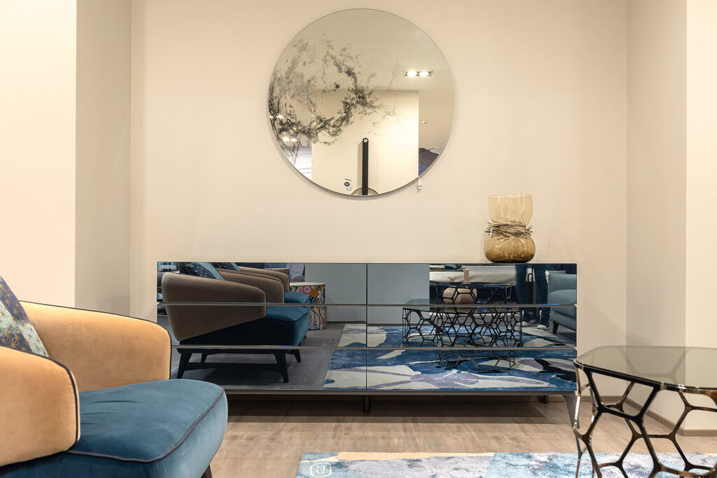 La commode en miroir, pièce maîtresse du style Hollywood Glamour, agrandit l'espace en reflétant la lumière du salon.